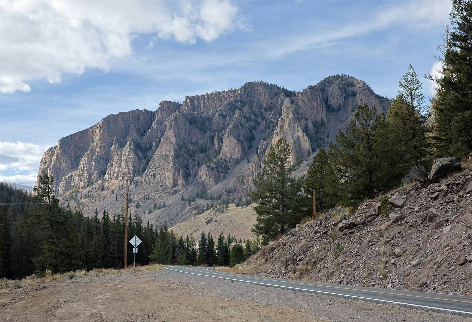 Highway 149 curving below tall cliffs of volcanic rock near Creede