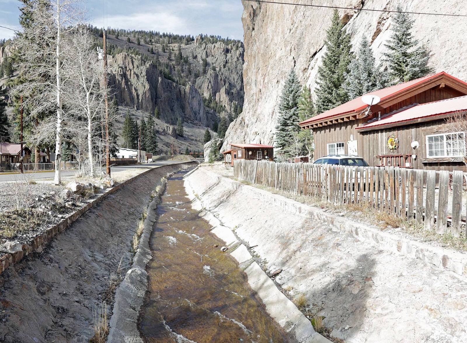 Willow Creek running through a stone channel beneath the cliffs at the north end of Creede