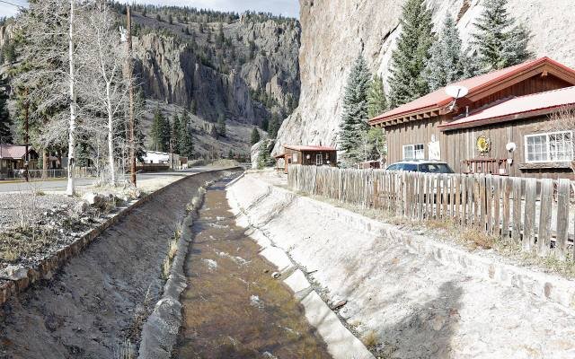 Willow Creek running through a stone channel beneath the cliffs at the north end of Creede
