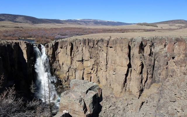 North Clear Creek Falls plunging into a dark rock canyon below open meadows