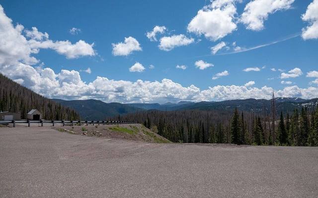 The overlook at Wolf Creek Pass with forested mountains under white clouds