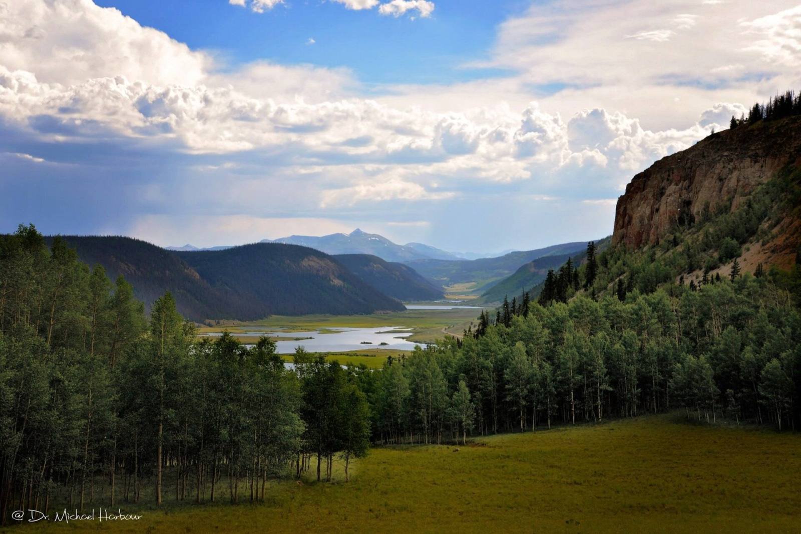 The upper Rio Grande valley near Creede seen from a forested hillside under summer clouds