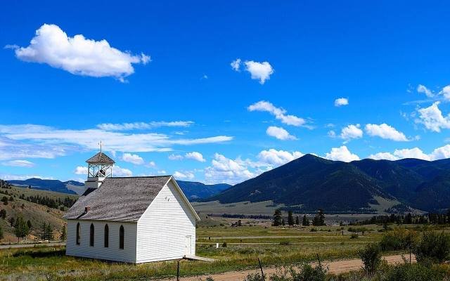 The white Sunnyside Chapel in a meadow below the mountains near Creede