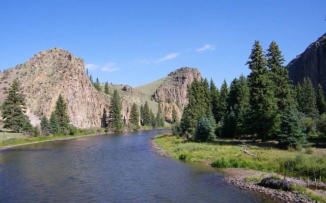 The Rio Grande flowing past cliffs and spruce trees below Creede