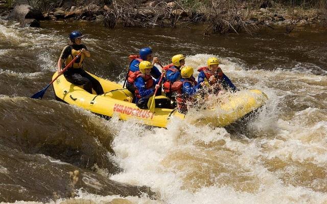 A raft crew paddling through whitewater on a Colorado river